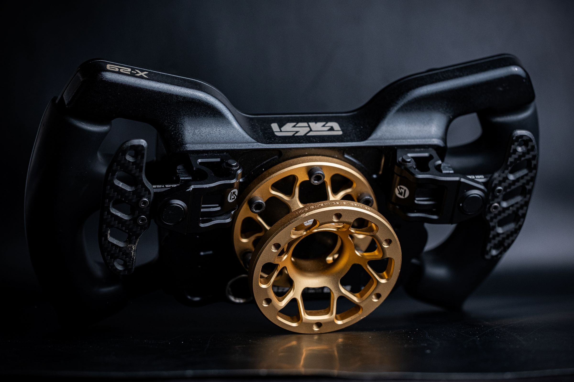 Close-up of a black and gold wheel hub attached to a GSI X-29 on a dark background