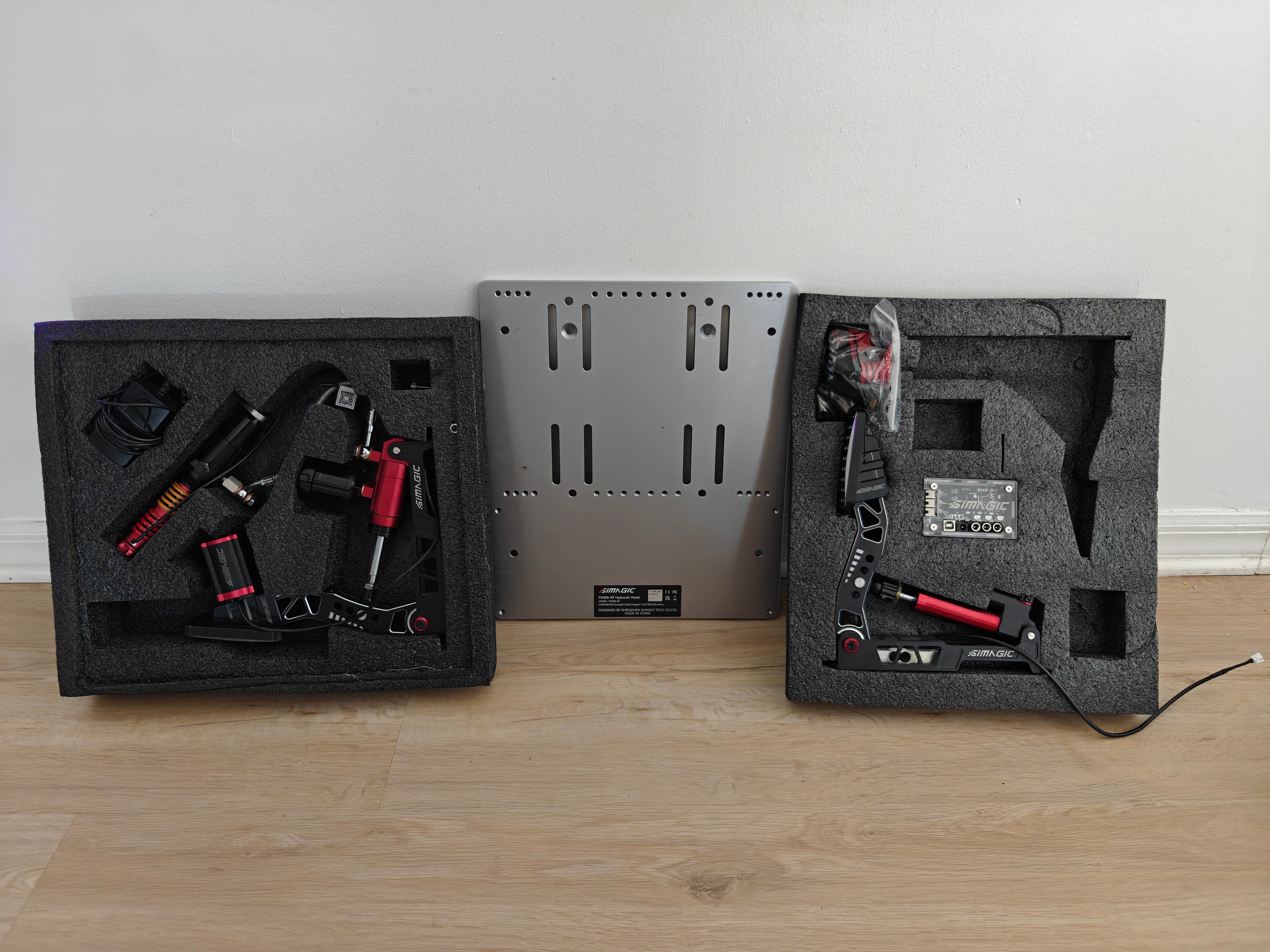 Used Simagic P2000 two-pedal set with baseplate, controller, accessories, and two haptic motors